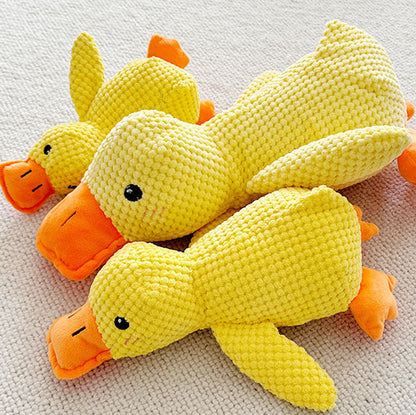Three yellow crochet duck toys on a textured surface